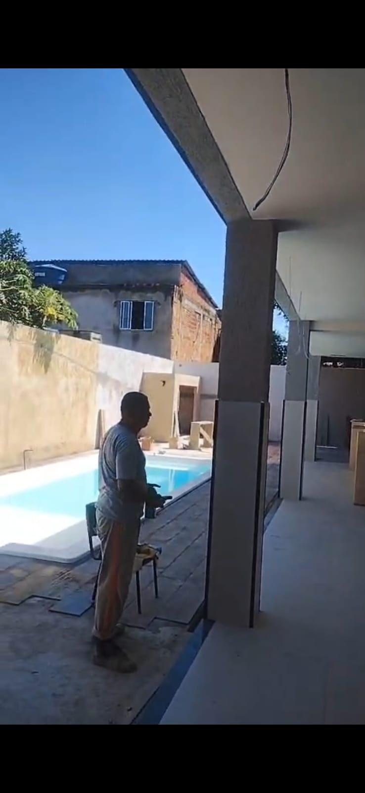 Área externa com piscina e obra de acabamento