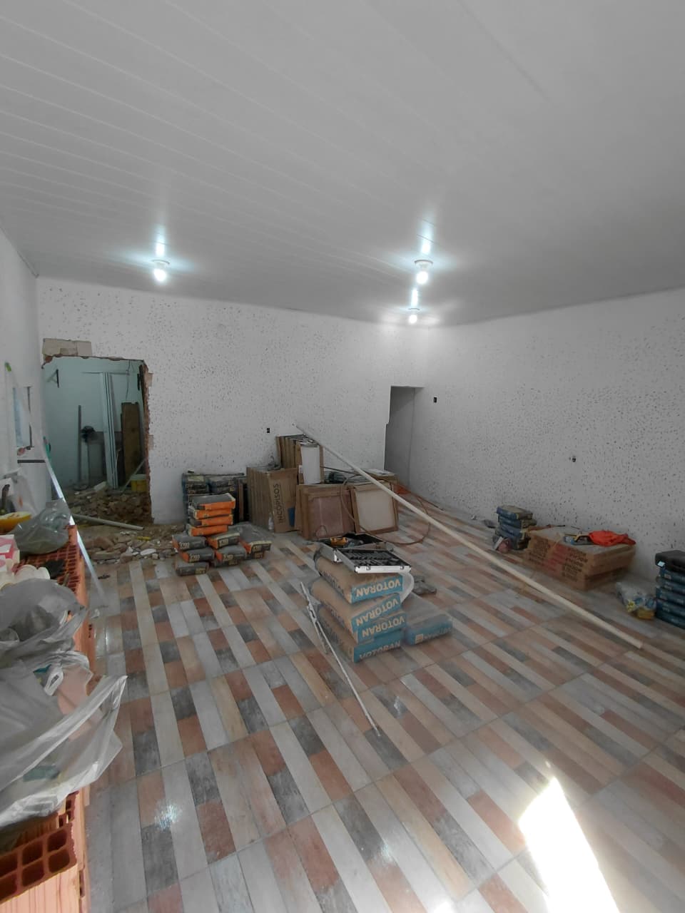 Sala residencial em reforma com revestimento de piso e preparação de paredes