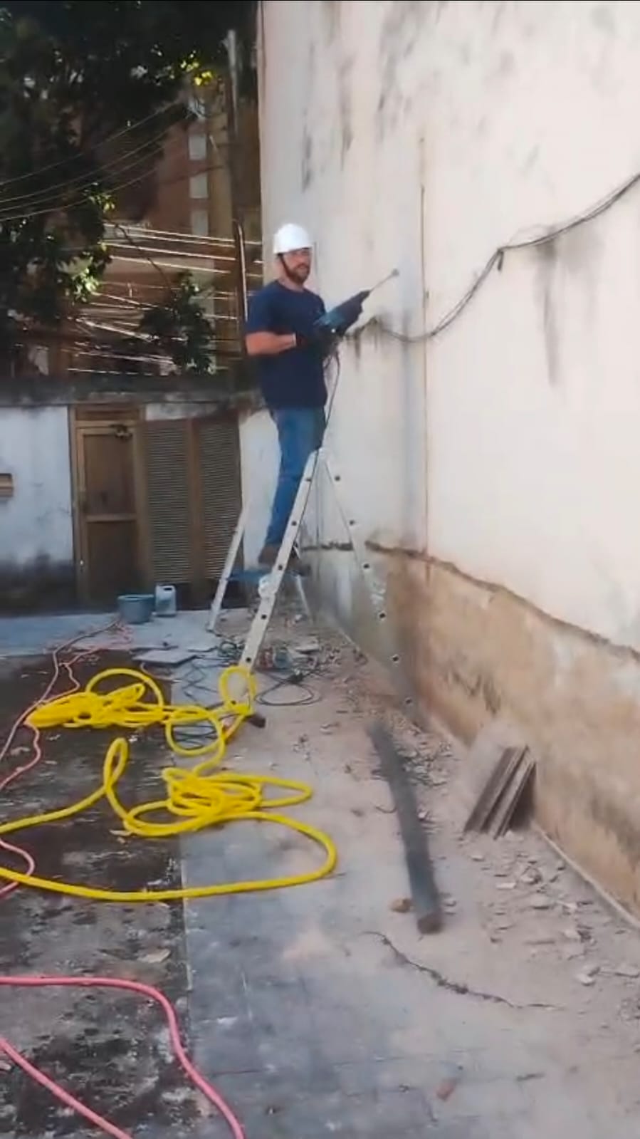 Profissional preparando parede externa para acabamento